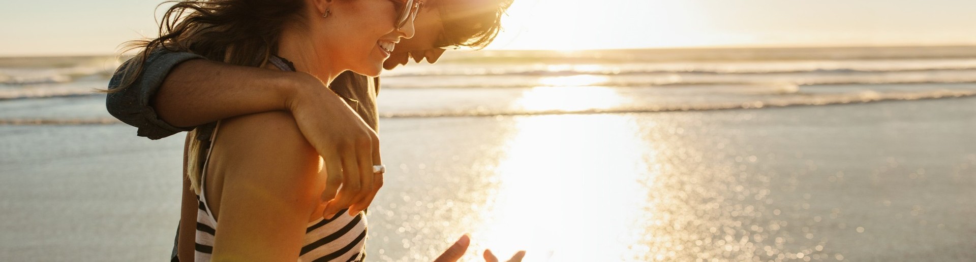 Photographie d'un couple se prenant par le main devant la mer